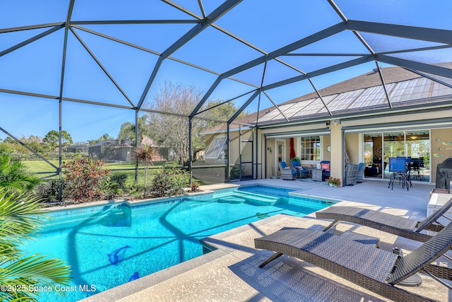 outdoor pool with outdoor lounge area, glass enclosure, and a patio area