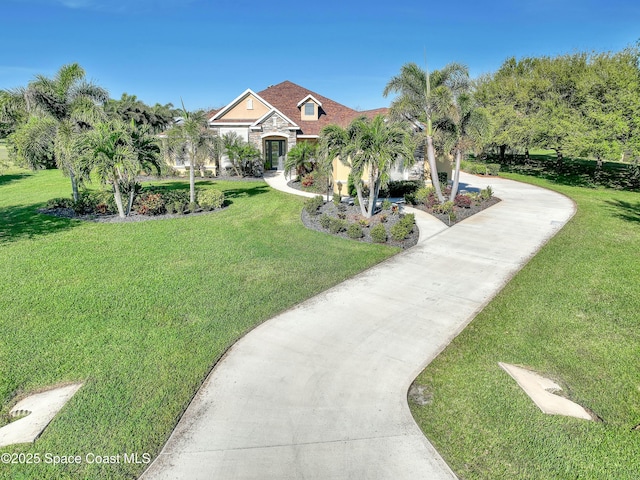 view of front facade featuring a front yard, concrete driveway, and stone siding