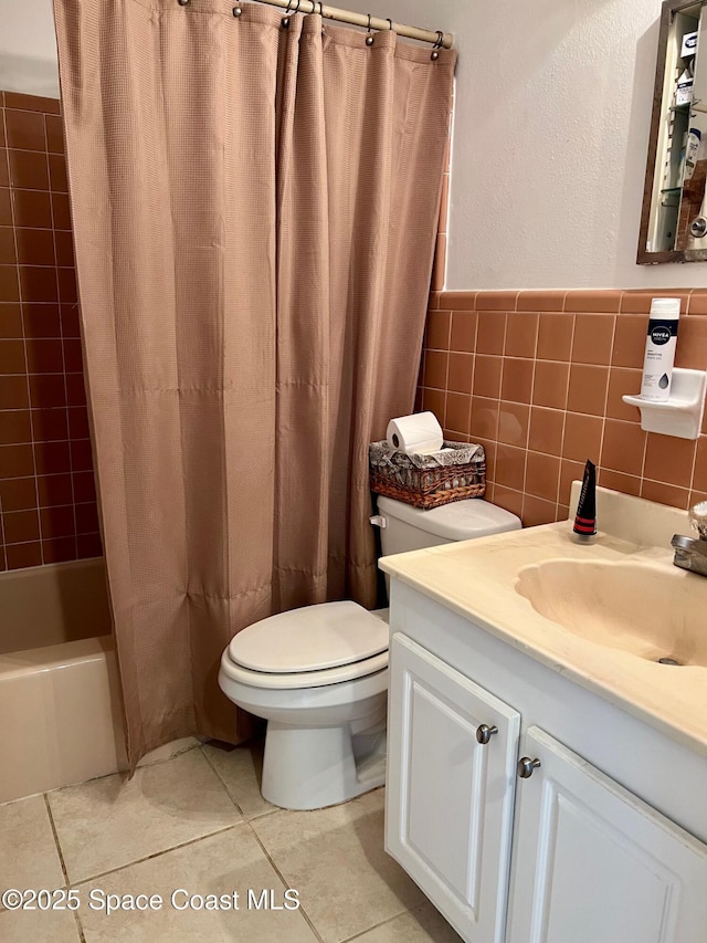 bathroom with toilet, tile patterned flooring, tile walls, shower / bath combination with curtain, and vanity