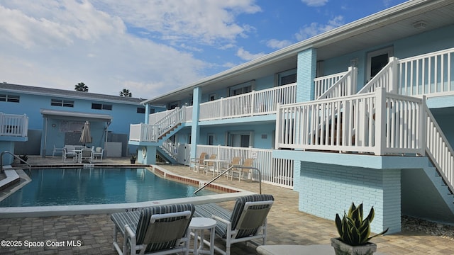 pool with a patio and stairway