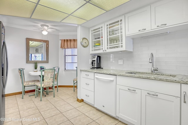 kitchen with a ceiling fan, a sink, white cabinets, dishwasher, and backsplash