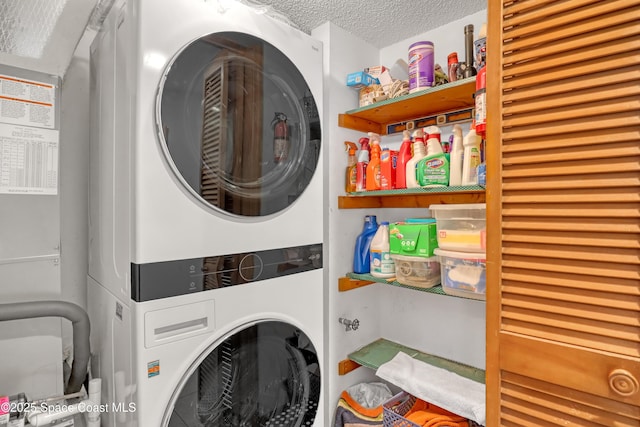 laundry room with laundry area, stacked washer / dryer, and a textured ceiling