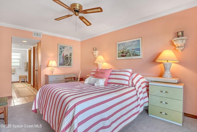 carpeted bedroom featuring visible vents, connected bathroom, baseboards, ornamental molding, and a closet