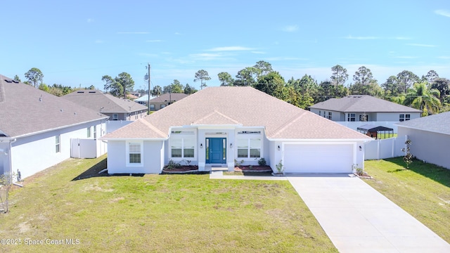 view of front of property featuring an attached garage, a front lawn, fence, roof with shingles, and driveway