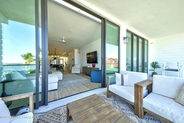 view of wooden balcony featuring a wooden deck, a ceiling fan, and outdoor lounge area