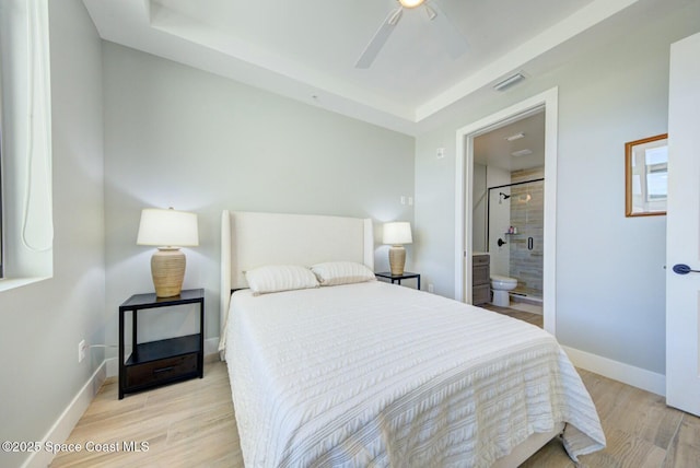 bedroom with visible vents, baseboards, light wood-style flooring, ensuite bath, and a ceiling fan