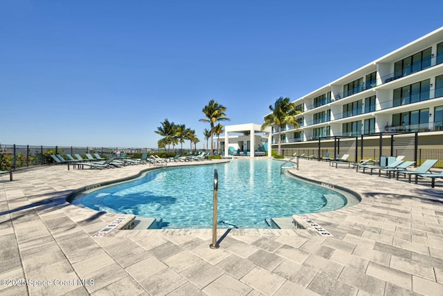 community pool with a patio and fence