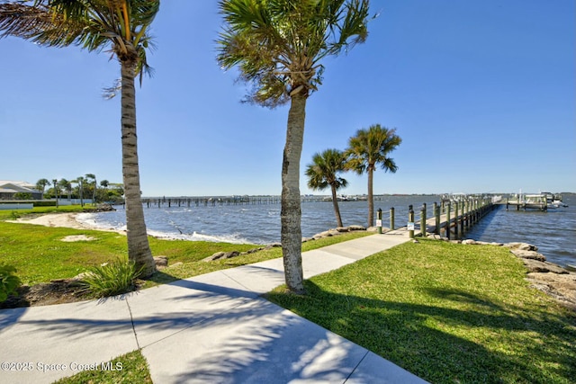 view of dock featuring a yard and a water view