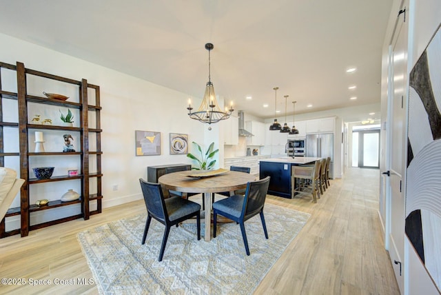 dining room featuring a notable chandelier, recessed lighting, light wood-style flooring, and baseboards