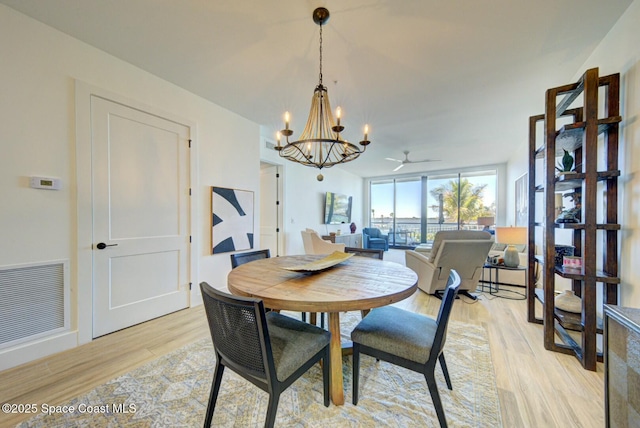 dining area with a notable chandelier, visible vents, and light wood-type flooring