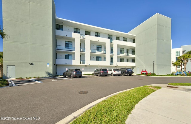 view of building exterior with uncovered parking