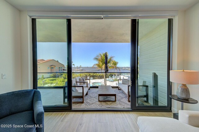 doorway to outside with expansive windows and wood finished floors