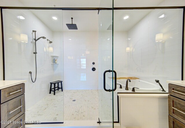 full bath featuring a stall shower, vanity, and a bath