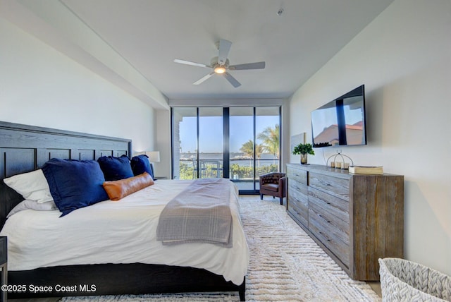 bedroom featuring ceiling fan, light colored carpet, and expansive windows