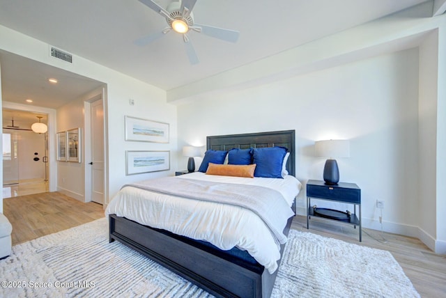 bedroom with a ceiling fan, wood finished floors, visible vents, baseboards, and recessed lighting