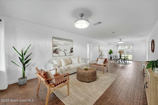 living room with visible vents, baseboards, and wood finished floors