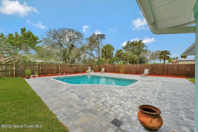 view of swimming pool featuring a fenced backyard, a fenced in pool, a lawn, and a patio