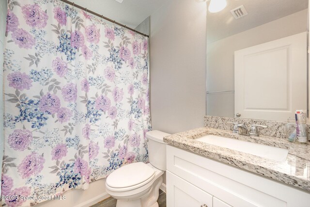 bathroom featuring visible vents, toilet, vanity, and a shower with curtain