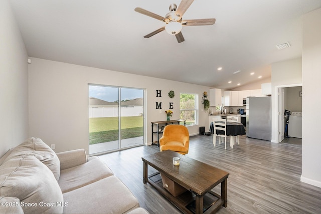 living area with visible vents, baseboards, vaulted ceiling, recessed lighting, and wood finished floors