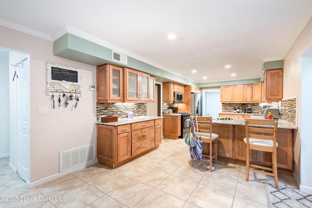 3530 Alan Dr, Titusville, FL 32780 - kitchen featuring a peninsula, visible vents, appliances with stainless steel finishes, and ornamental molding