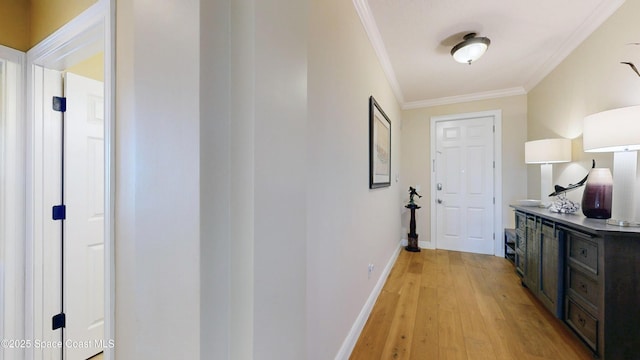 interior space featuring baseboards, light wood-style floors, and crown molding