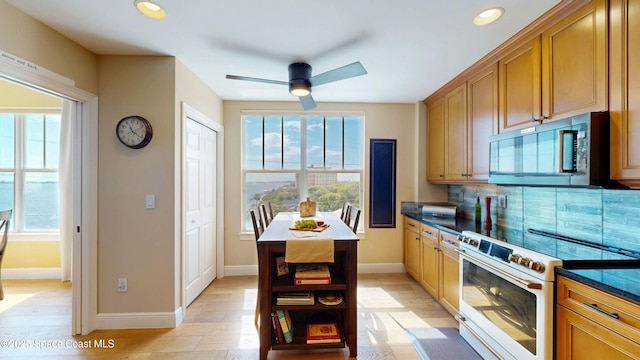 kitchen with dark countertops, stainless steel microwave, backsplash, white range with electric cooktop, and open shelves