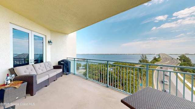 balcony featuring a water view and outdoor lounge area