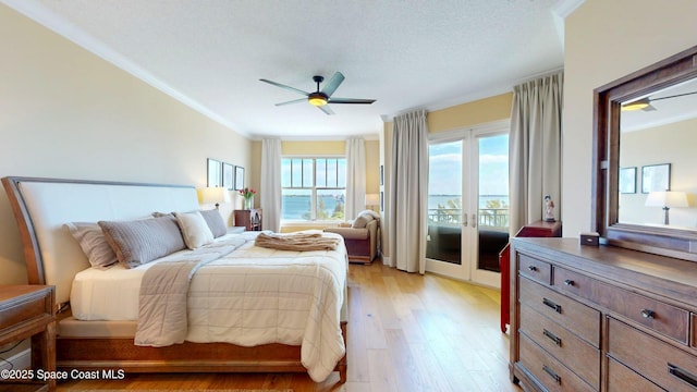 bedroom with access to exterior, crown molding, light wood-style flooring, french doors, and a ceiling fan