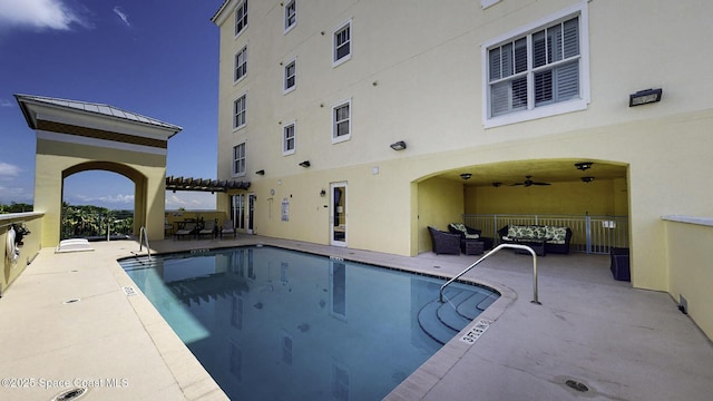 pool with a patio area, ceiling fan, and a pergola