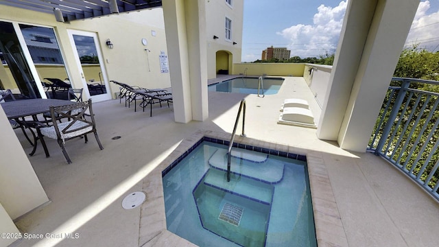 view of swimming pool featuring a community hot tub and outdoor dining area