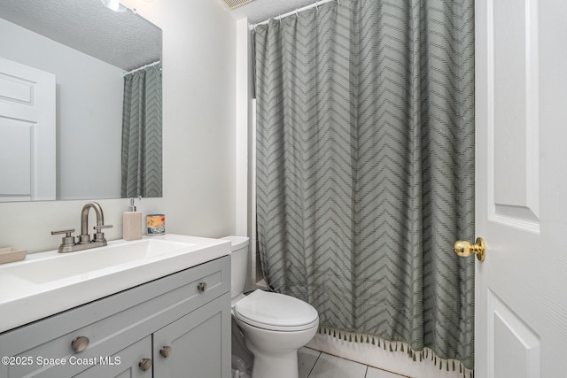 bathroom featuring vanity, tile patterned floors, toilet, and a textured ceiling