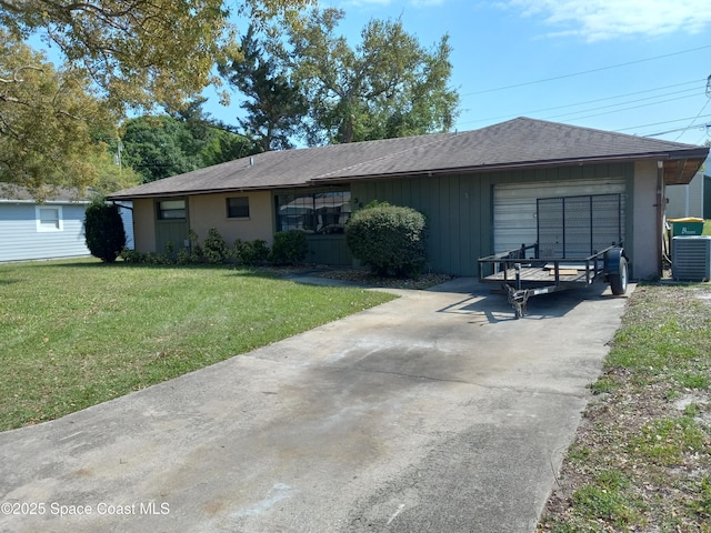 ranch-style home with an attached garage, a shingled roof, a front lawn, central AC unit, and driveway