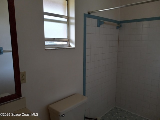 bathroom featuring toilet and a tile shower