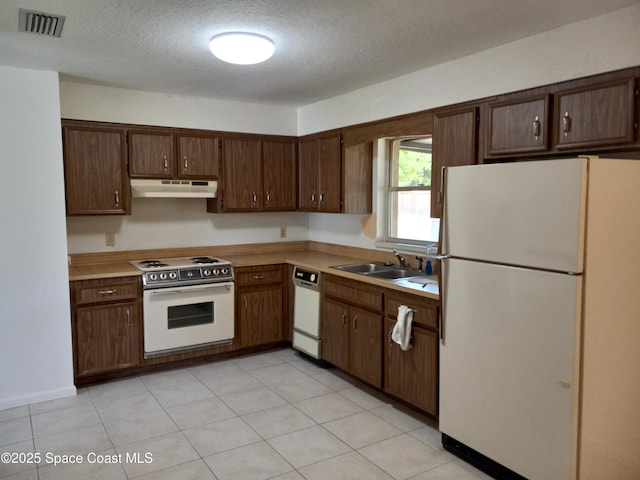 kitchen featuring white appliances, visible vents, a sink, under cabinet range hood, and a textured ceiling