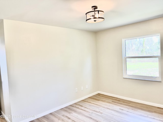 empty room featuring baseboards and wood finished floors