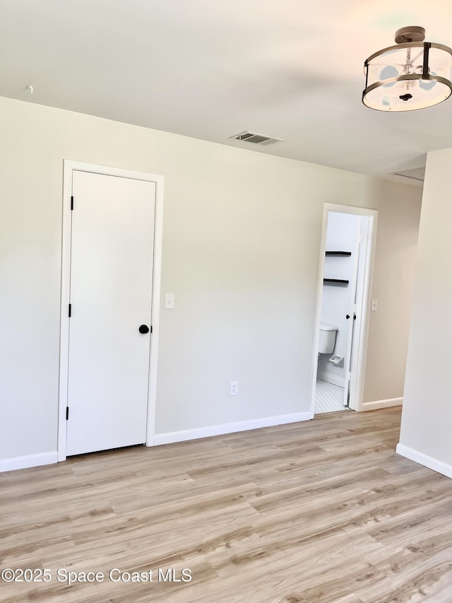 spare room featuring baseboards, visible vents, and light wood finished floors