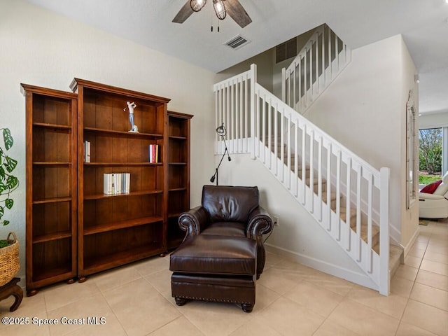 living area with visible vents, a ceiling fan, tile patterned flooring, baseboards, and stairs