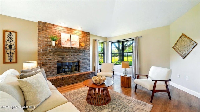 living area with a fireplace, wood finished floors, and baseboards