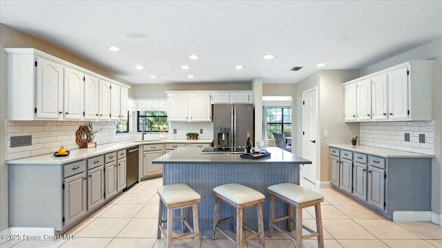 kitchen with appliances with stainless steel finishes, light tile patterned flooring, and gray cabinets