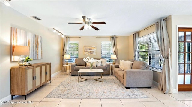 living area featuring light tile patterned floors, baseboards, visible vents, and ceiling fan