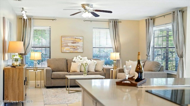 living room with a wealth of natural light, light tile patterned flooring, and a ceiling fan