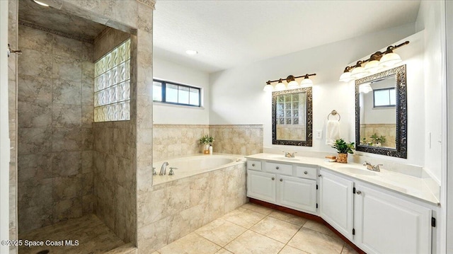 bathroom with tile patterned flooring, double vanity, a bath, and a sink