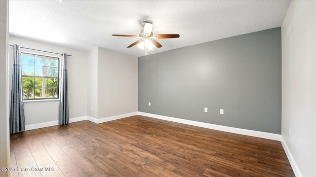 empty room with ceiling fan, baseboards, a textured ceiling, and wood finished floors