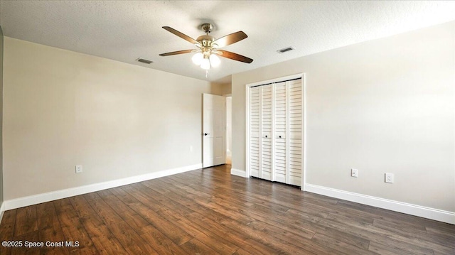 unfurnished bedroom featuring dark wood-type flooring, baseboards, and visible vents