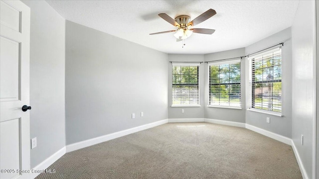 unfurnished room with baseboards, carpet, ceiling fan, and a textured ceiling