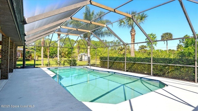 outdoor pool featuring glass enclosure and a patio