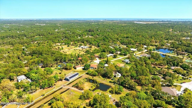 drone / aerial view with a forest view and a water view