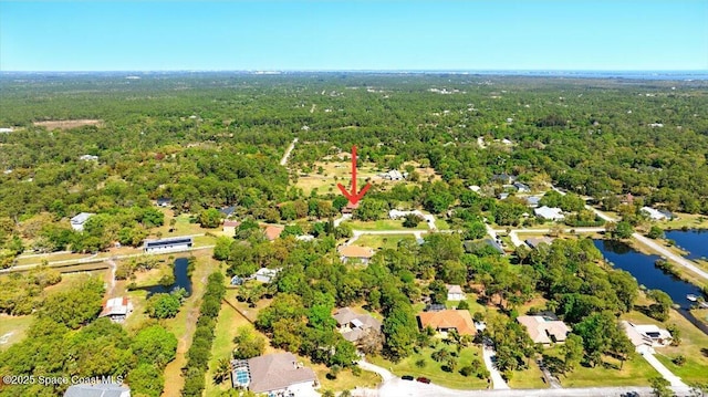 drone / aerial view featuring a forest view and a water view