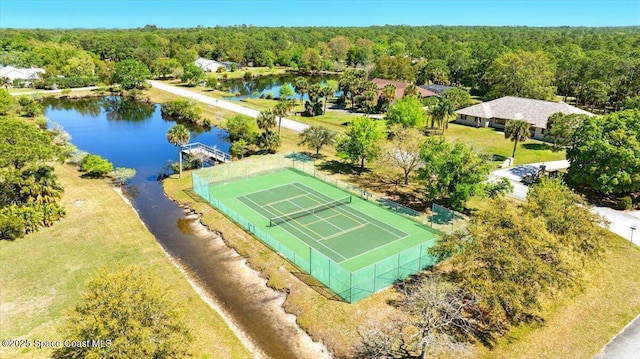 birds eye view of property featuring a forest view and a water view