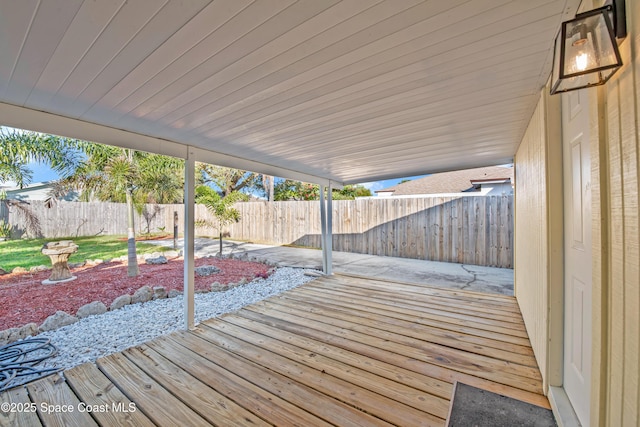 wooden deck featuring a patio area and a fenced backyard